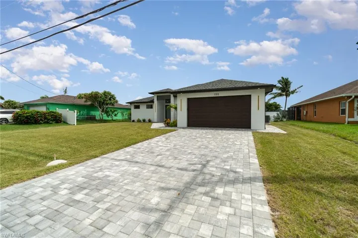 View of front of house with a garage and a front yard