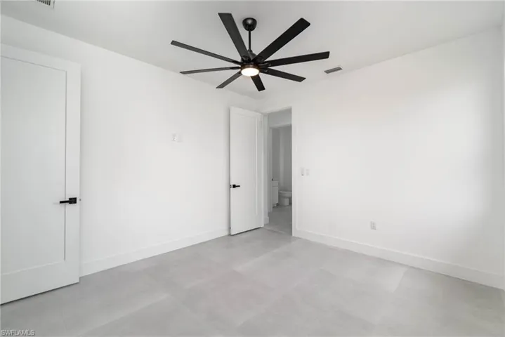 Empty room featuring light tile patterned floors and ceiling fan