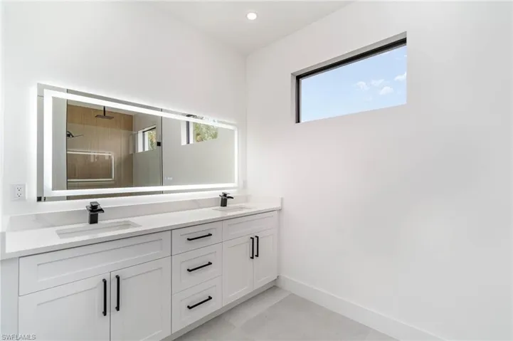 Bathroom featuring tile patterned flooring and dual bowl vanity