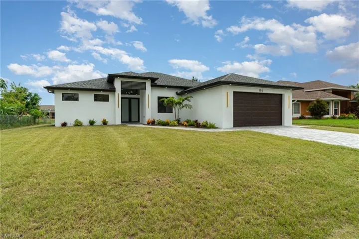 Prairie-style home with a garage and a front lawn