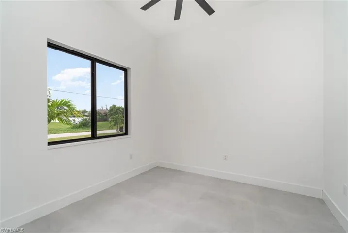Spare room with ceiling fan and a wealth of natural light