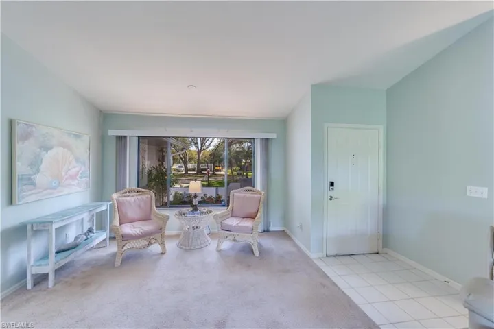Living area with light carpet and baseboards