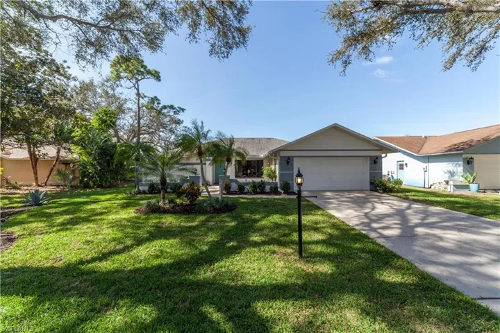 Single story home featuring concrete driveway, a front yard, an attached garage, and stucco siding