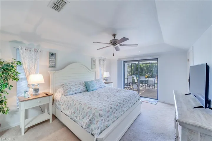 Bedroom featuring access to exterior, light colored carpet, and ceiling fan