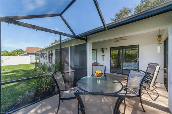 Lanai with a ceiling fan, outdoor dining area, and lofted ceiling