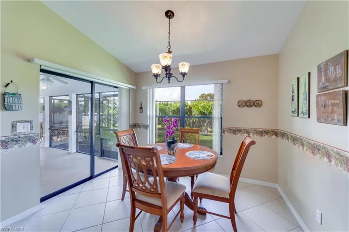 Dining space featuring vaulted ceiling, suspended lighting, light tile patterned floors, and a ceiling fan