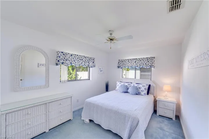 Bedroom with light colored carpet and ceiling fan