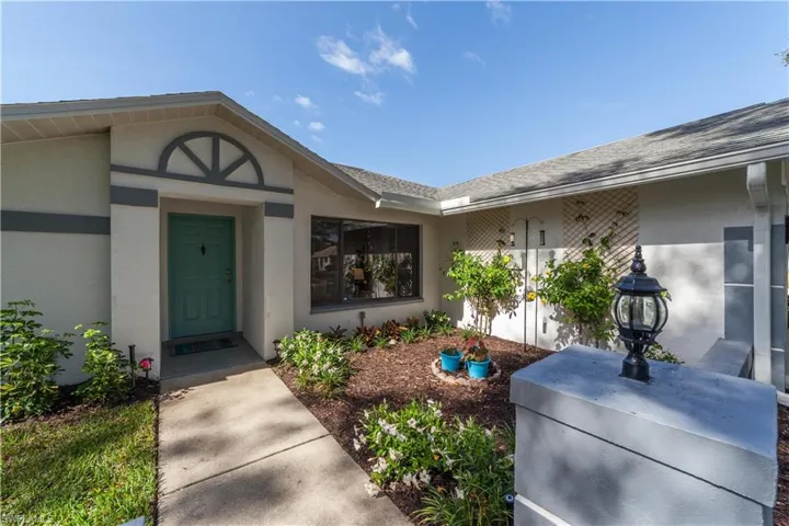 Property entrance with stucco siding and a shingled roof