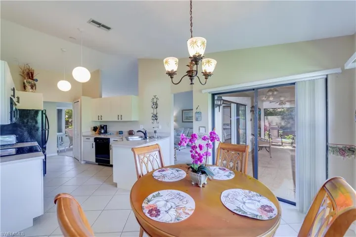 Dining area with lofted ceiling, hanging lights, and light tile patterned floors