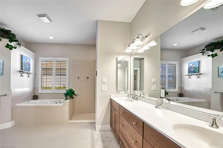 Bathroom with tile patterned flooring, vanity, and shower with separate bathtub