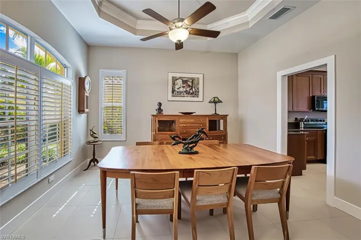 Dining area featuring crown molding, a raised ceiling, and ceiling fan