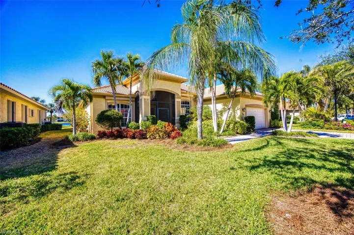 Mediterranean / spanish home featuring a garage and a front lawn