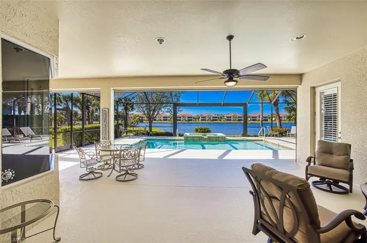 View of pool with ceiling fan and a water view
