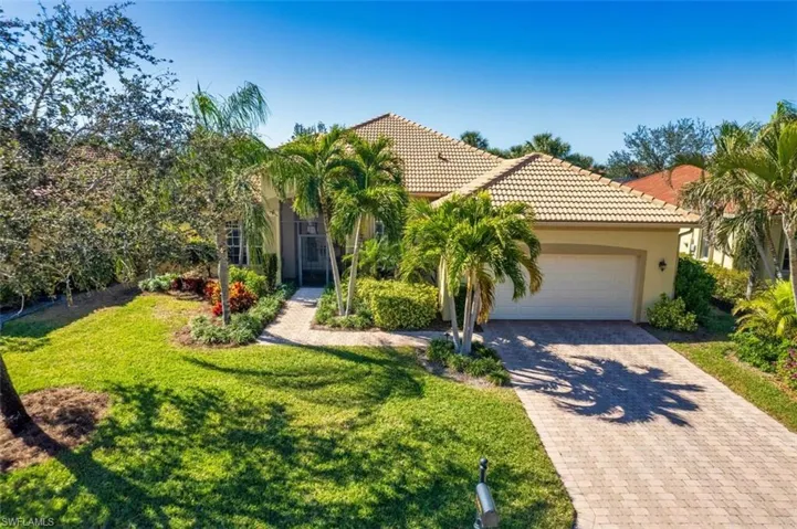 Mediterranean / spanish house featuring a garage and a front yard