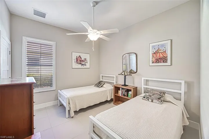 Tiled bedroom featuring ceiling fan