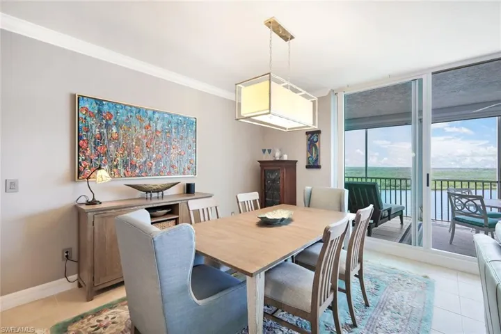 Dining area with floor to ceiling windows, light tile patterned floors, a wealth of natural light, and ornamental molding