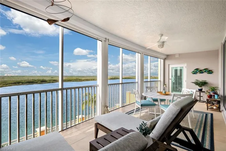 Sunroom / solarium featuring a water view and ceiling fan