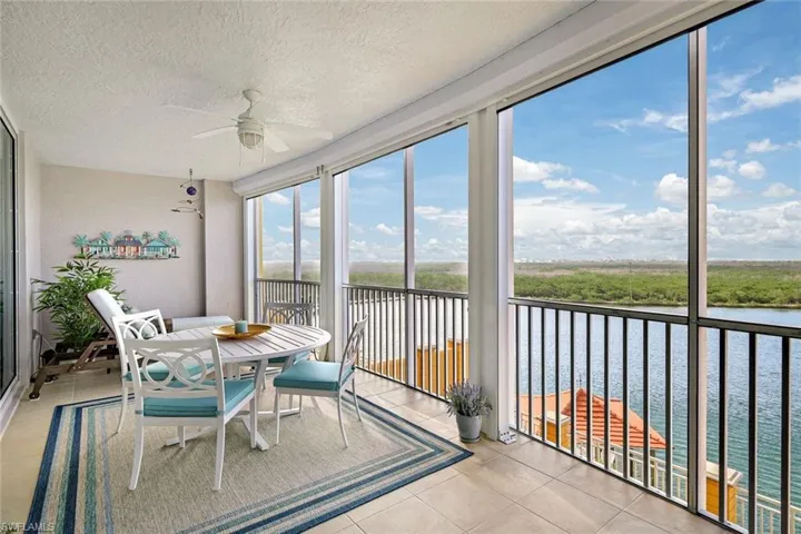 Sunroom featuring ceiling fan and a water view