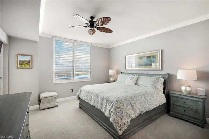 Bedroom featuring ceiling fan, light colored carpet, and crown molding