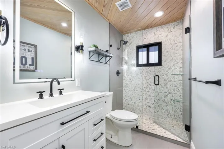 Guest bathroom features a luxury walk-in shower, illuminated mirror and quartz countertops.