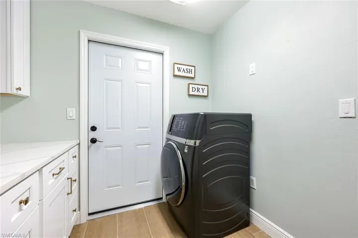 The laundry room features a GE profile washer/dryer combination unit AND additional storage.