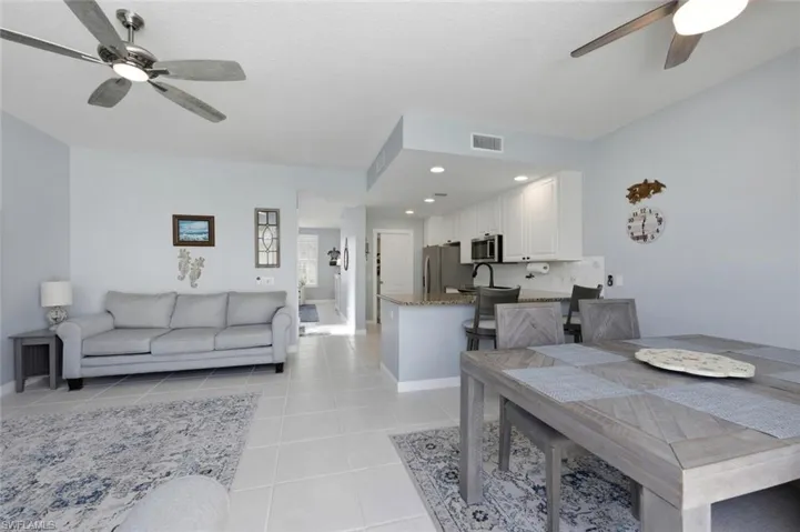 Living area with ceiling fan and light tile patterned floors