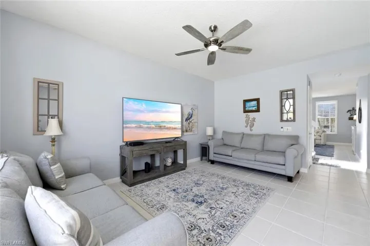 Living room featuring light tile patterned floors and a ceiling fan