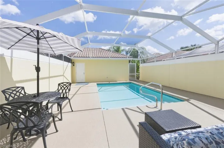 Swimming pool with a sunroom, a patio, and glass enclosure