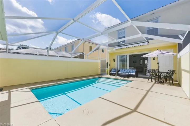 Swimming pool featuring a sunroom, a lanai, a patio area, and outdoor dining space