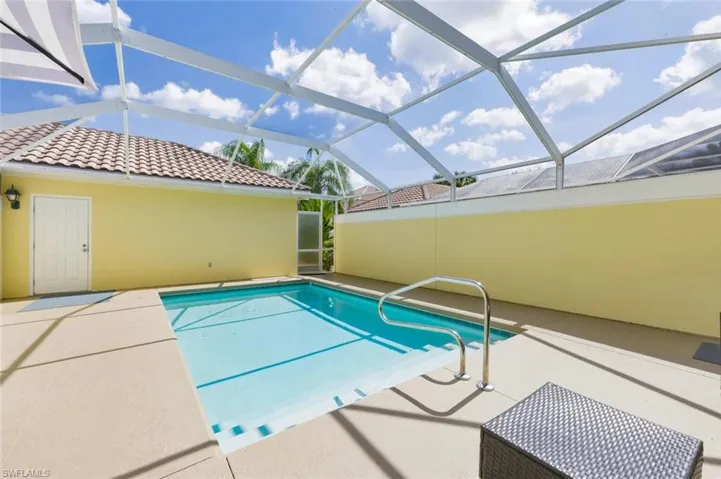 Outdoor pool with a sunroom, a patio, and glass enclosure