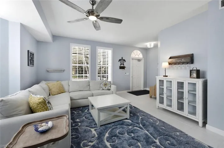Living room featuring a ceiling fan and light tile patterned floors