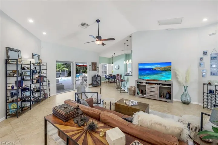 Living area with vaulted ceilings, recessed lighting, and tile flooring