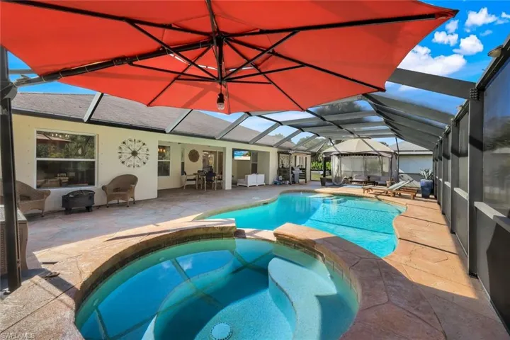 Screened outdoor living area almost 2k sq ft featuring a freeform swimming pool, integrated spa, and textured concrete decking