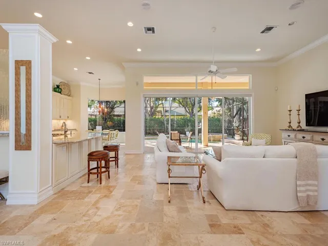 Living Room with tile flooring throughout, ceiling fan and crown molding.