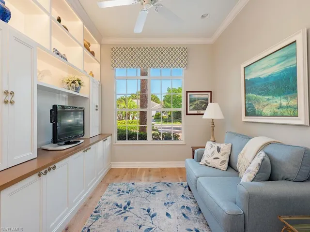 Den, crown molding, light and bright with wood flooring.