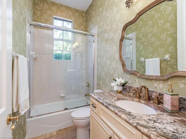 Full bathroom featuring vanity, toilet, and enclosed tub / shower combo