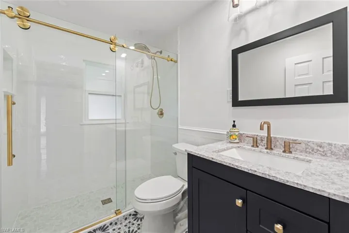 Bathroom with vanity, toilet, and an enclosed shower