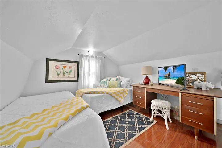 Bedroom with lofted ceiling and dark hardwood / wood-style floors