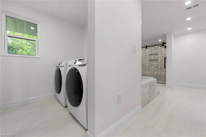 Laundry room with independent washer and dryer and a barn door