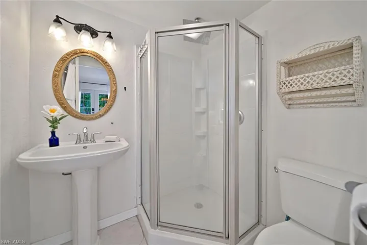 Bathroom with a shower with shower door, toilet, and sink