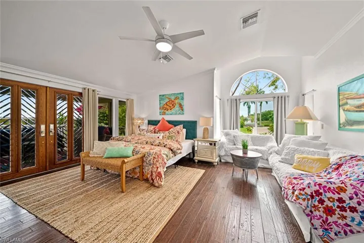 Bedroom featuring french doors, access to exterior, dark hardwood / wood-style flooring, lofted ceiling, and ceiling fan
