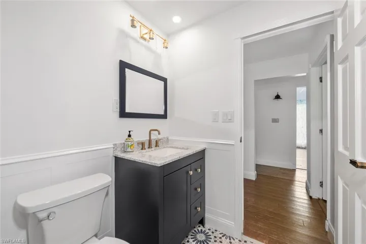 Bathroom featuring wood-type flooring, toilet, and vanity