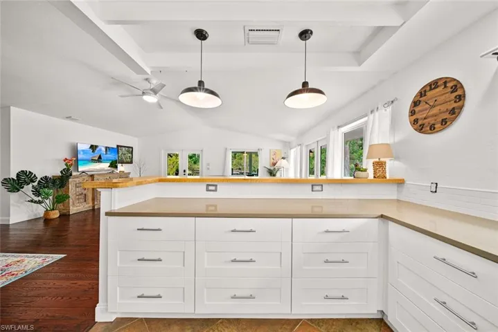 Kitchen featuring pendant lighting, dark hardwood / wood-style flooring, white cabinetry, and ceiling fan