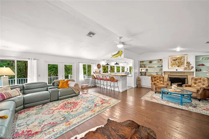 Living room featuring ceiling fan, lofted ceiling, and dark hardwood / wood-style floors