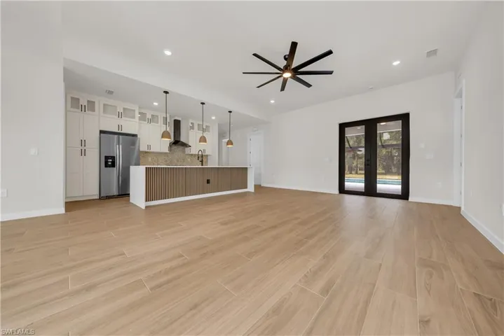 Unfurnished living room featuring french doors, ceiling fan, light wood-style flooring, and recessed lighting