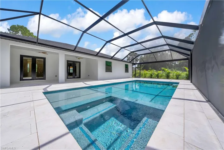 View of swimming pool with a sunroom, ceiling fan, a lanai, a patio, and a pool with connected hot tub