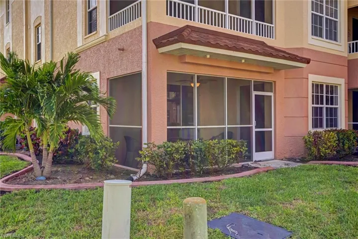Inviting front entry featuring screened lanai, stucco siding, and manicured lawn — welcome to 1133 Van Loon Commons, Cape Coral