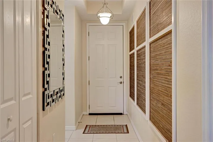 Tiled entryway door opening to the screened lanai and outdoor living area