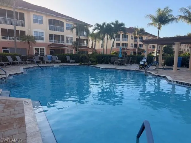 Resort-style community pool with expansive paver patio and covered pergola — perfect for Florida outdoor living