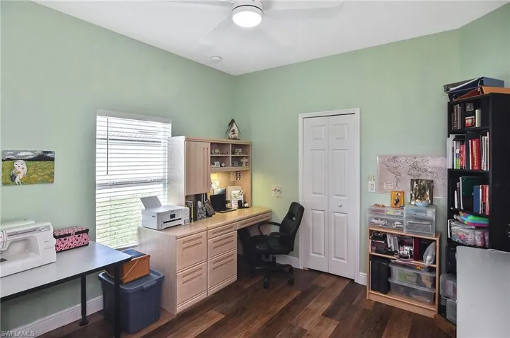 Office space with dark wood-style floors and a ceiling fan